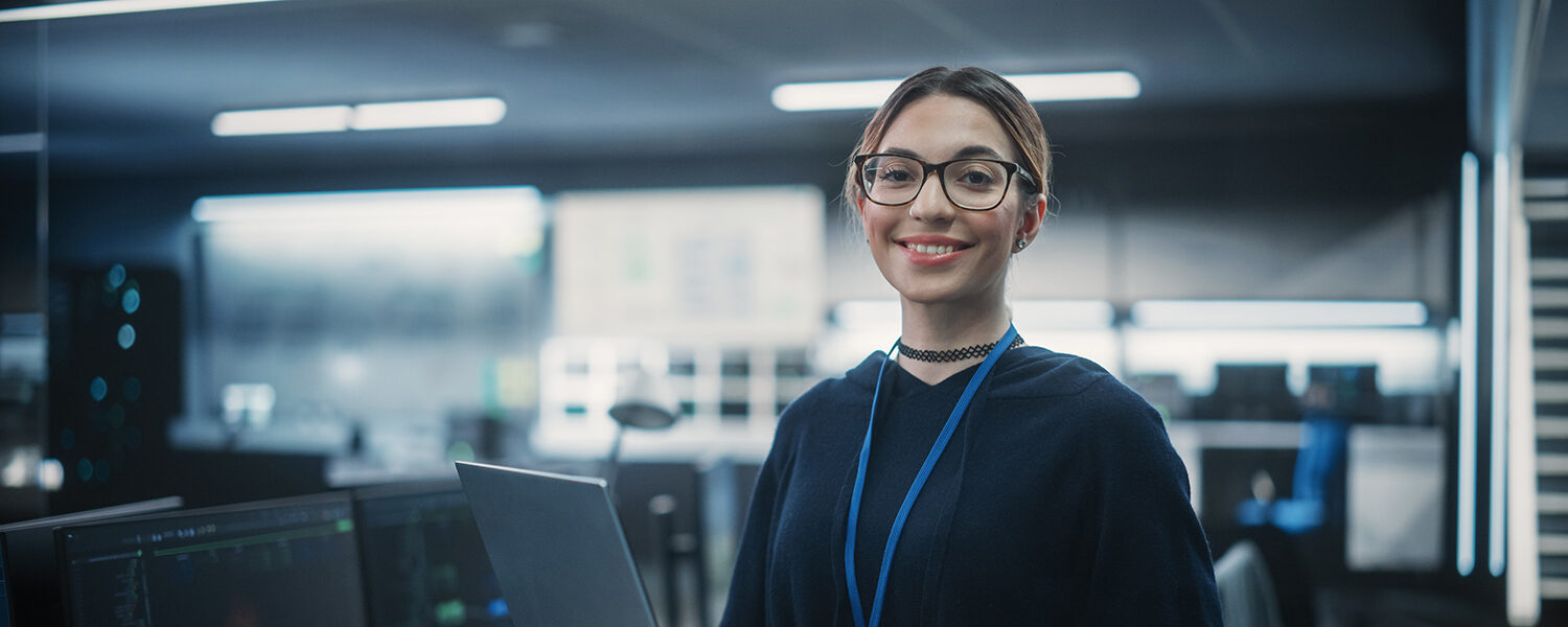 Portrait of a young woman smiling holding a laptop