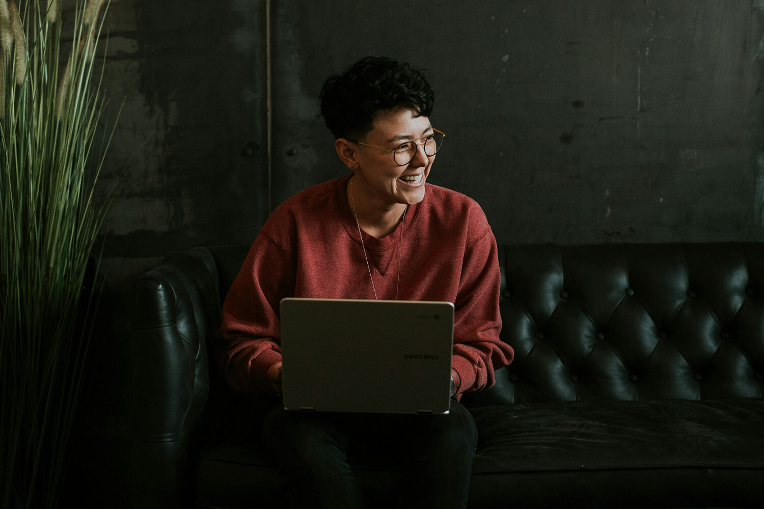 Woman on Sofa smiling with laptop